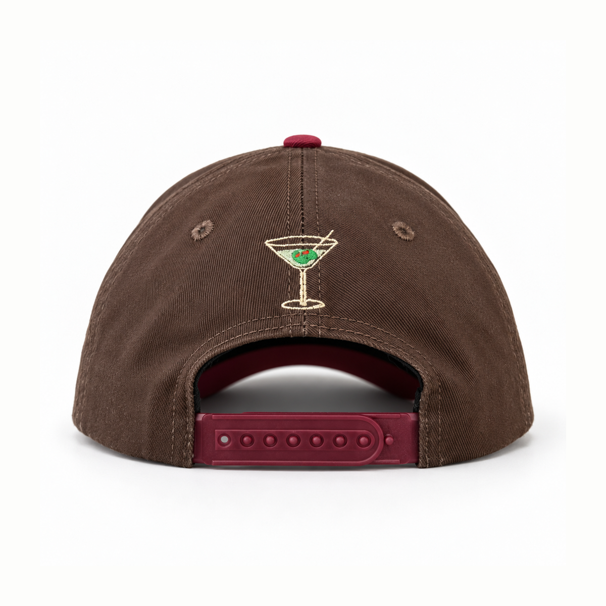 A brown canvas snapback cap shown from the back, featuring a small embroidered martini glass with a green olive on the center back panel and a burgundy adjustable strap.