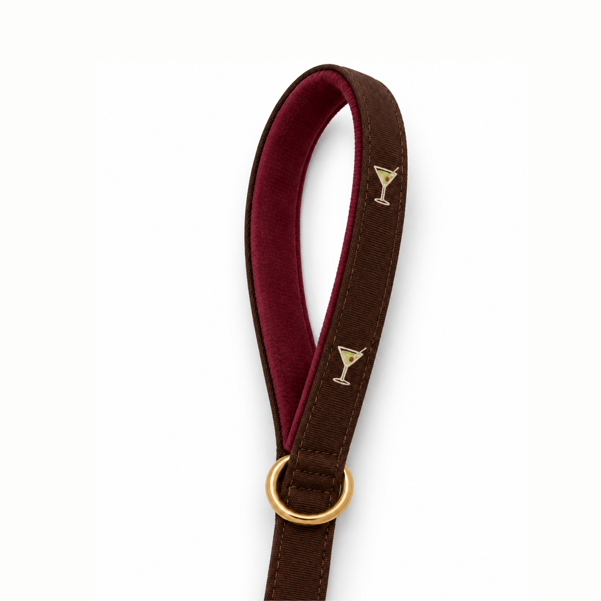 A dark brown leather dog leash with a deep burgundy velvet inner lining and gold-tone metal hardware, including a small martini glass emblem.