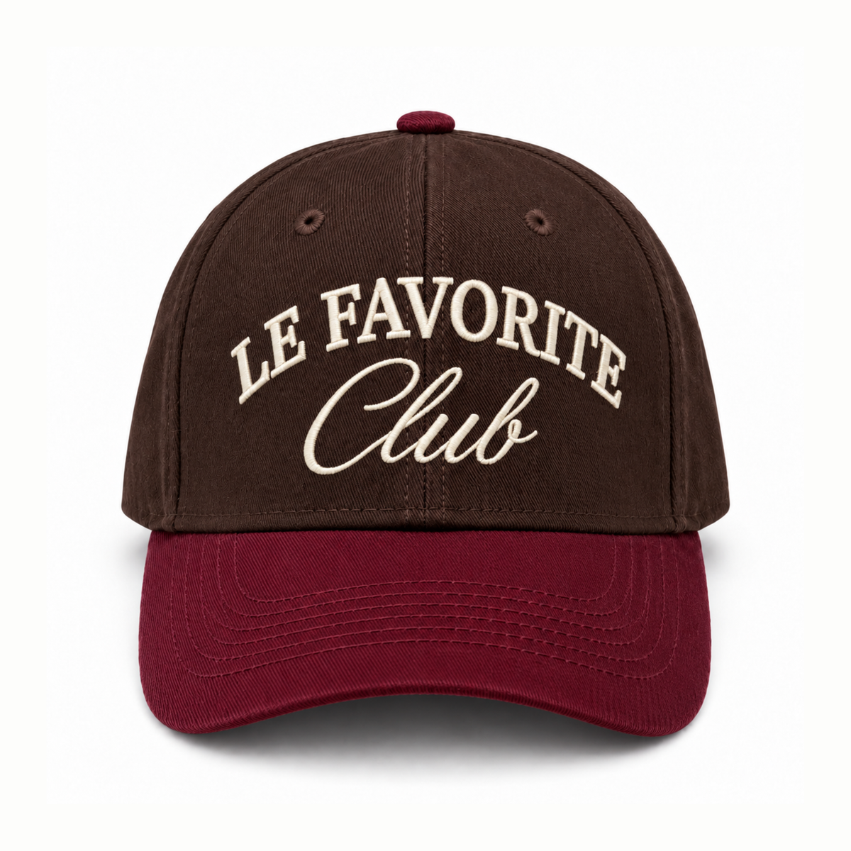 A baseball cap with a dark brown crown and a burgundy curved brim, featuring 'LE FAVORITE Club' embroidered on the front in cream lettering, set against a plain white background.